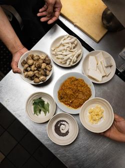 Several plates with mushrooms, sliced paneer, spices, and curry ingredients at Jazba East Village Indian restaurant