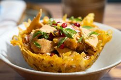 Crispy Indian appetizer served in an edible fried basket garnished with pomegranate seeds and microgreens.